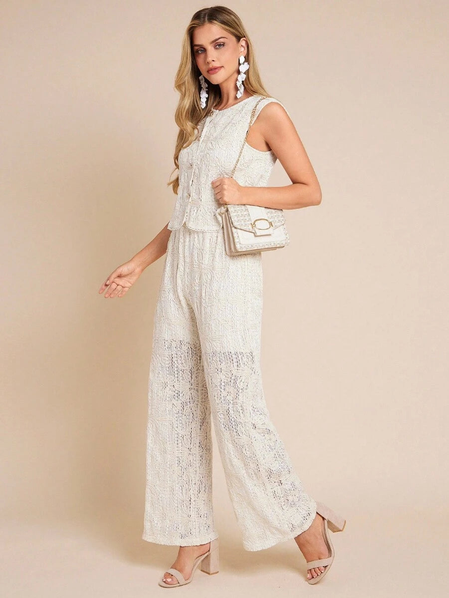Woman wearing a white lace jumpsuit against a beige background