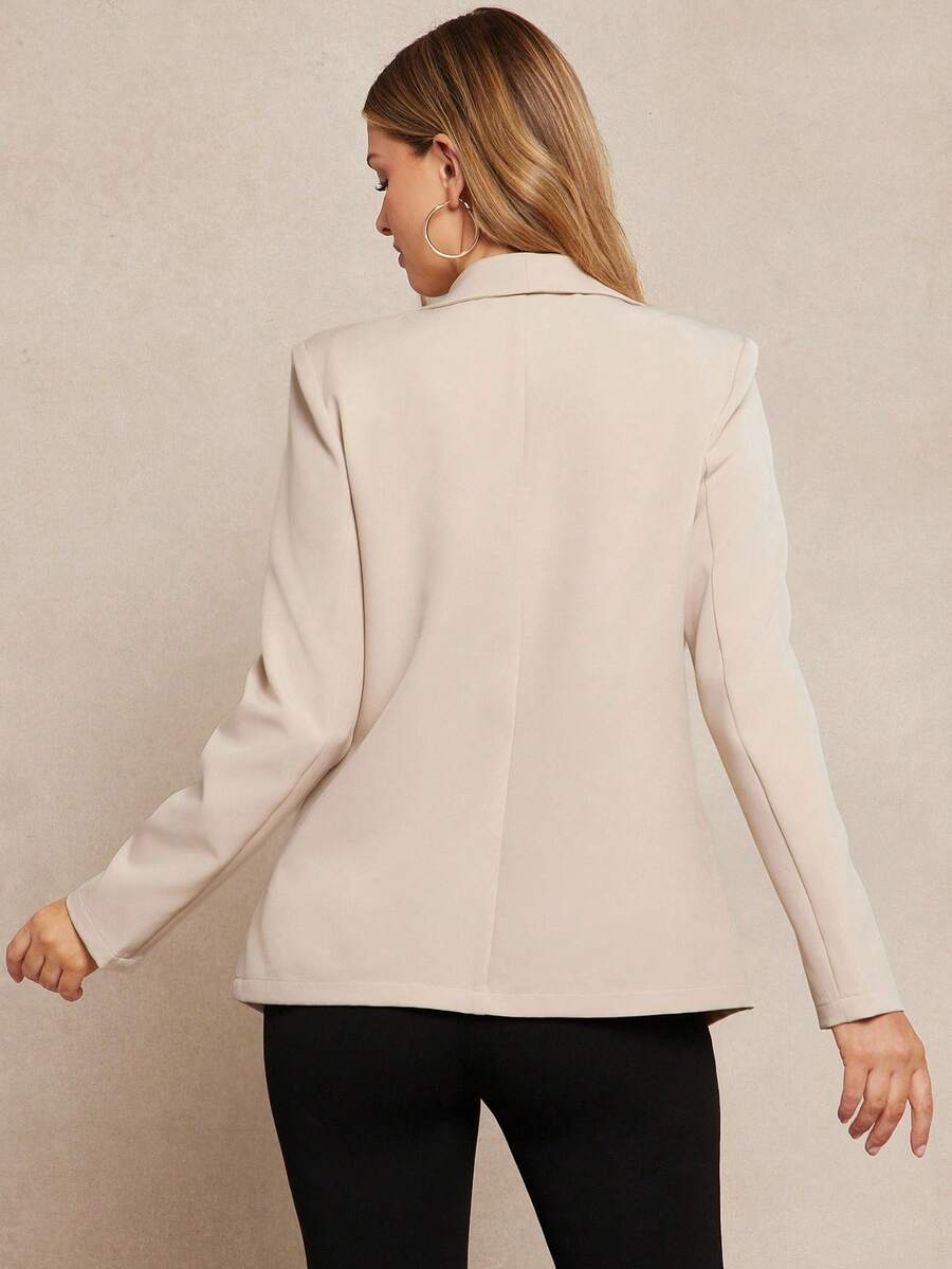 Woman wearing a beige blazer against a beige background