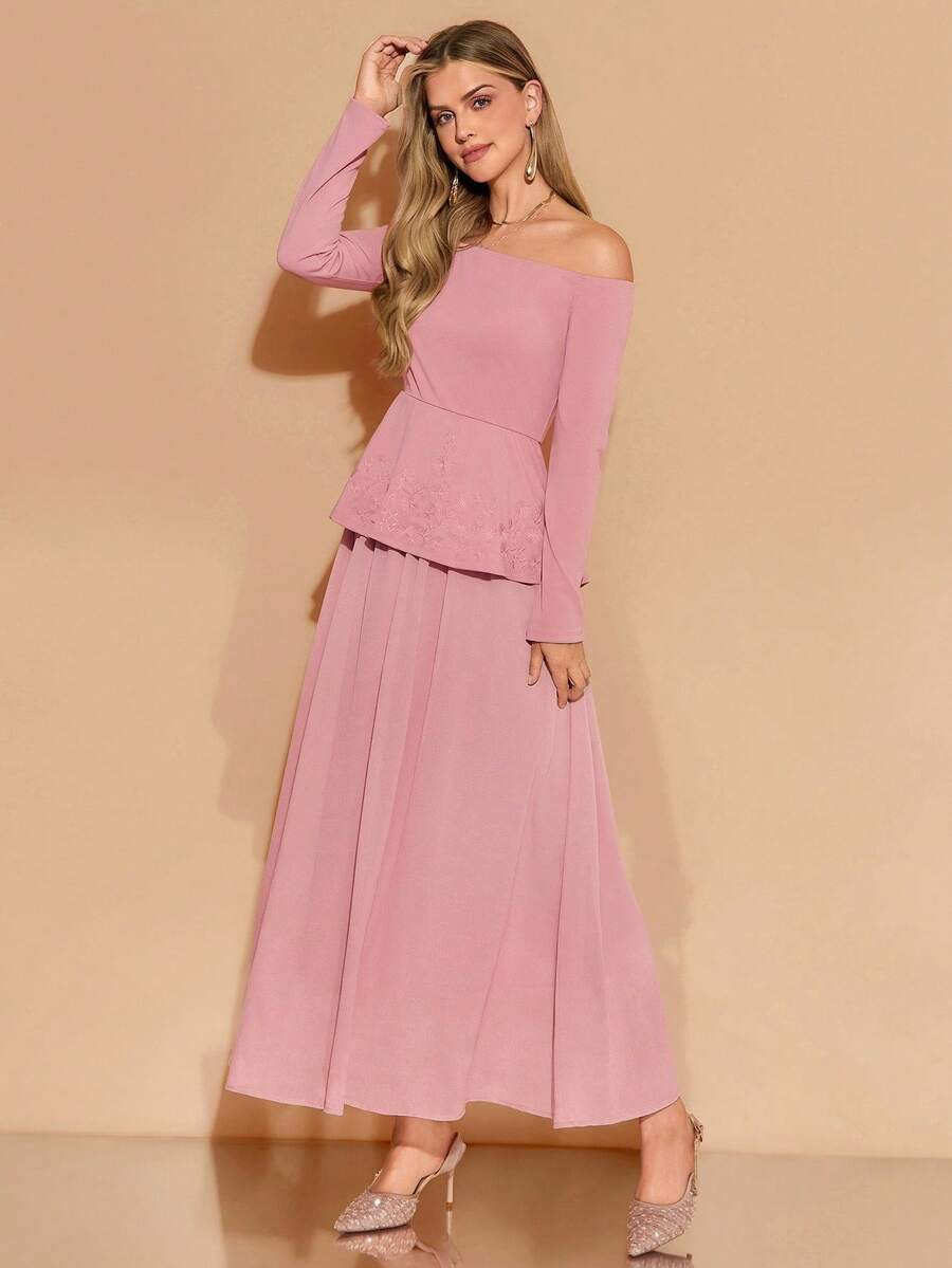 Woman wearing a pink off-shoulder top and long skirt against a beige background
