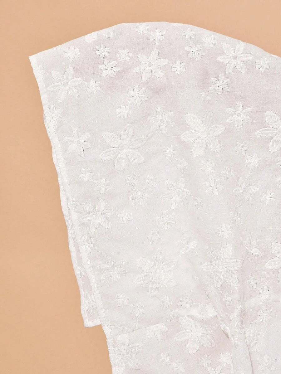 White lace fabric with floral patterns on a beige background