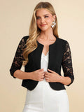 Woman wearing a black lace-trimmed jacket over a white top on a beige background