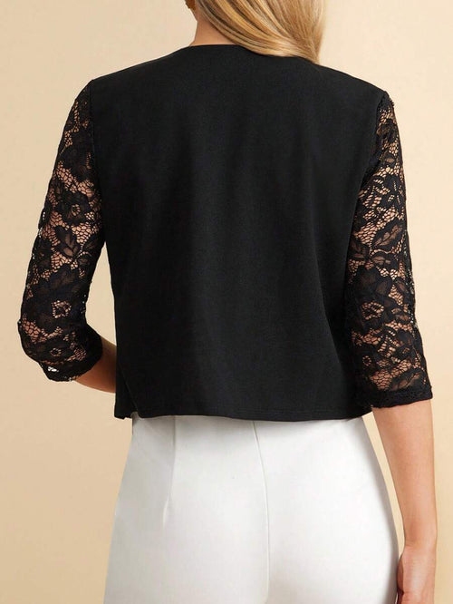 Black jacket with lace sleeves worn by a person on a beige background