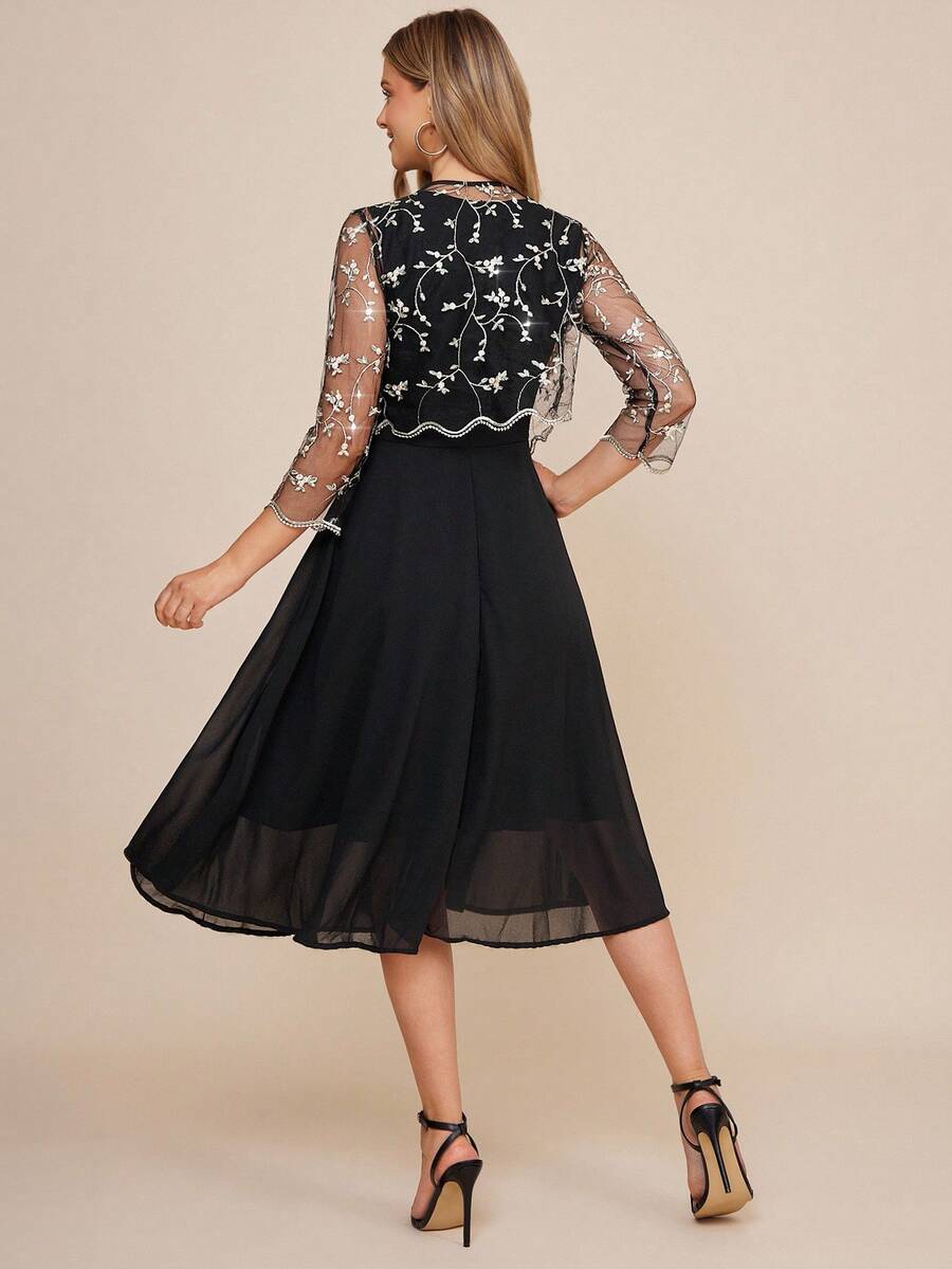 Black dress with floral lace details on a beige background