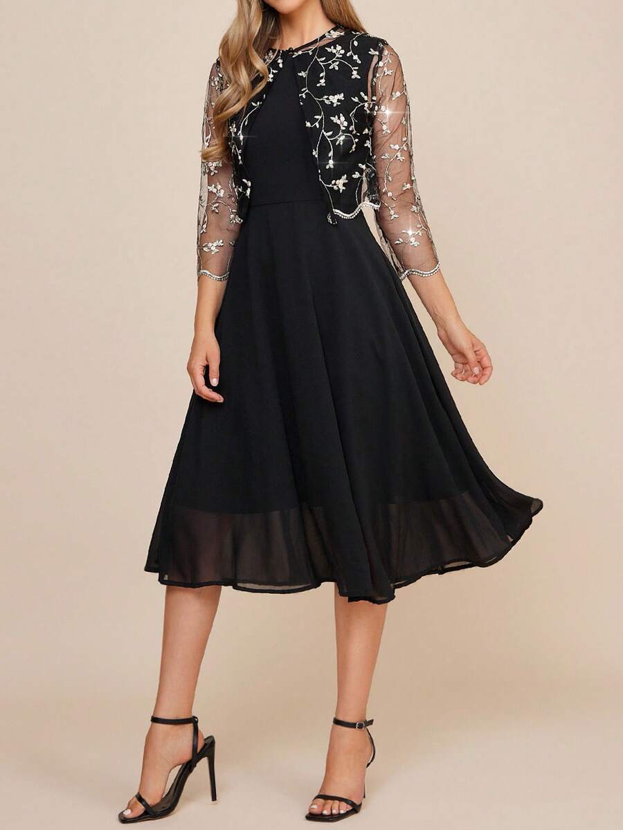 Black dress with floral lace sleeves on a beige background