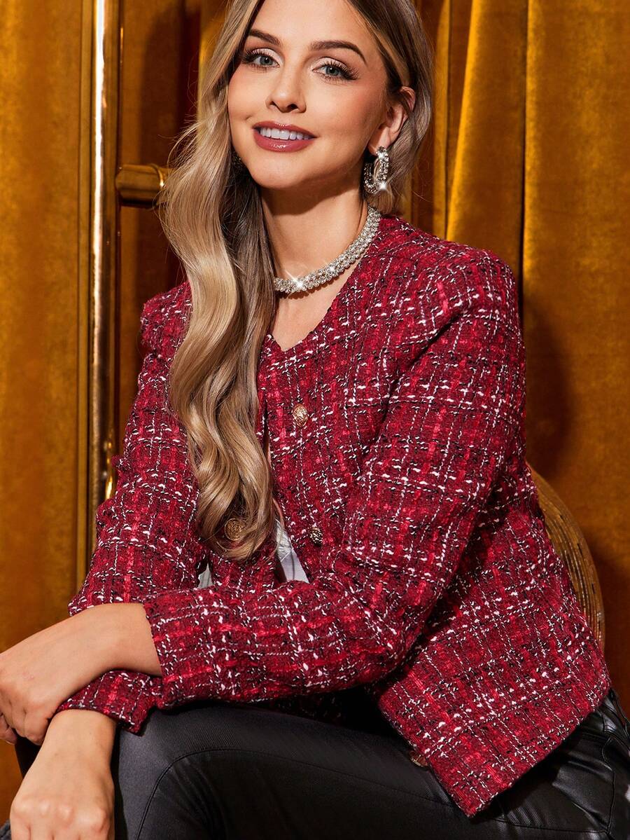 Woman wearing a red patterned jacket against a gold curtain background