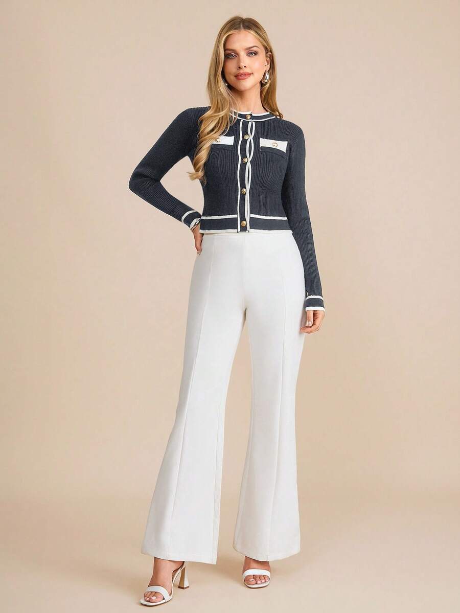 Woman wearing a dark blue cardigan with white accents on a beige background
