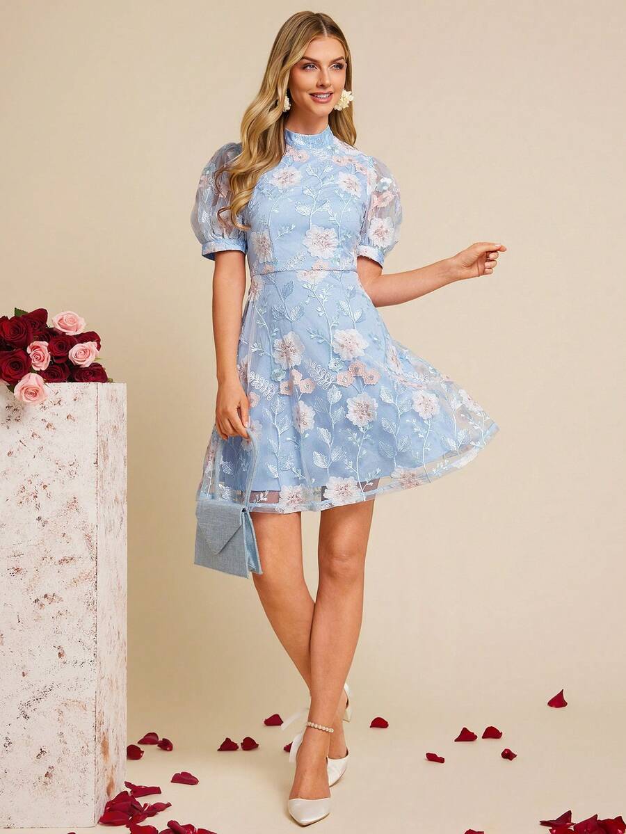 Woman wearing a light blue floral dress standing against a beige background with decorative elements.