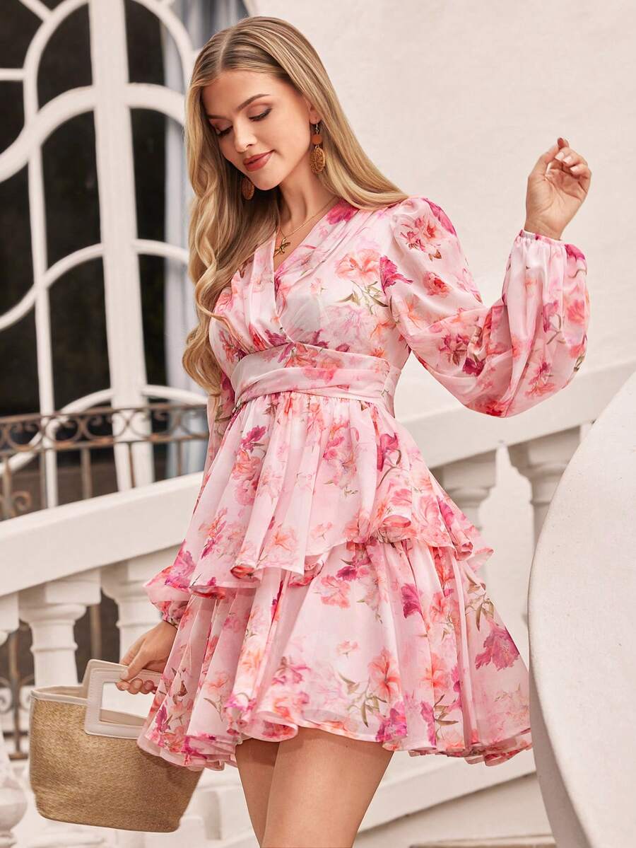 Woman wearing a pink floral dress standing outdoors.