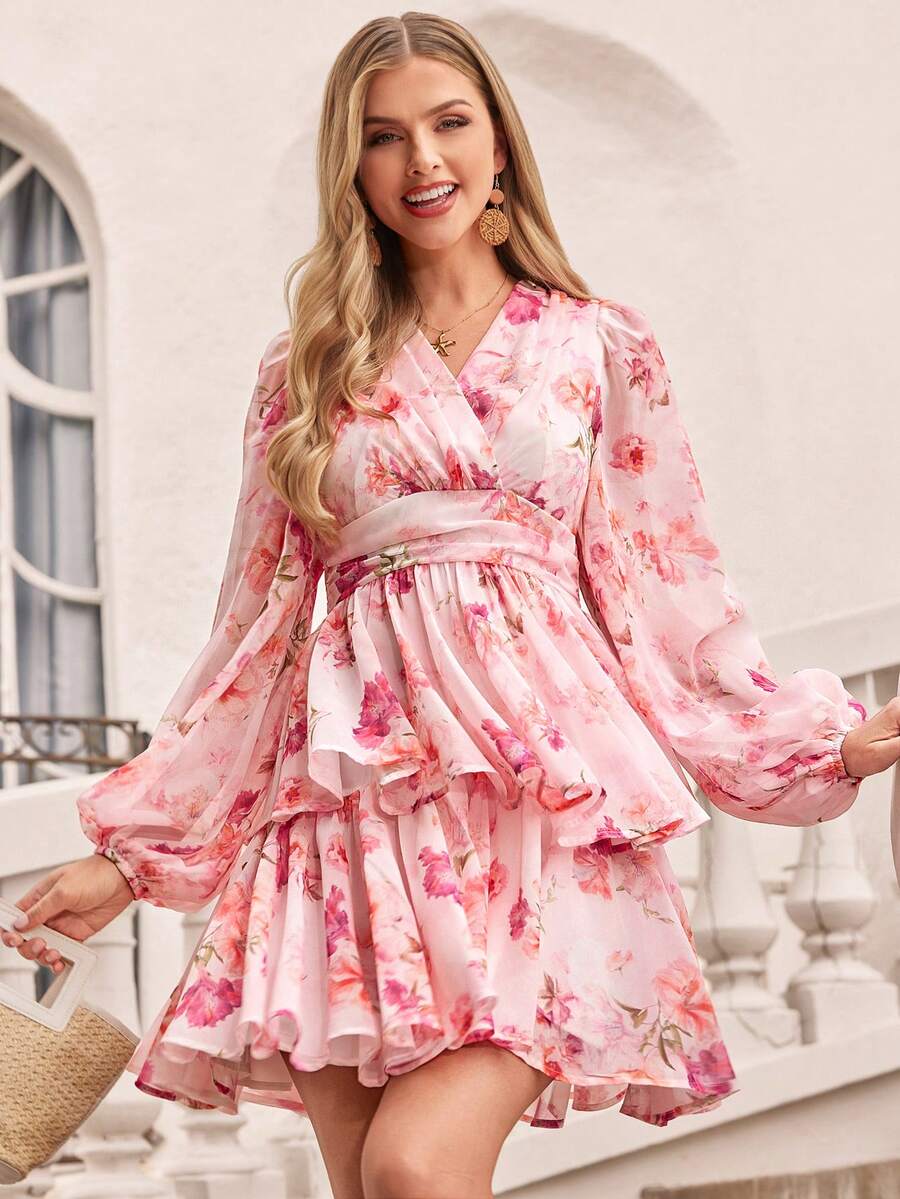 Woman wearing a pink floral dress standing outdoors.