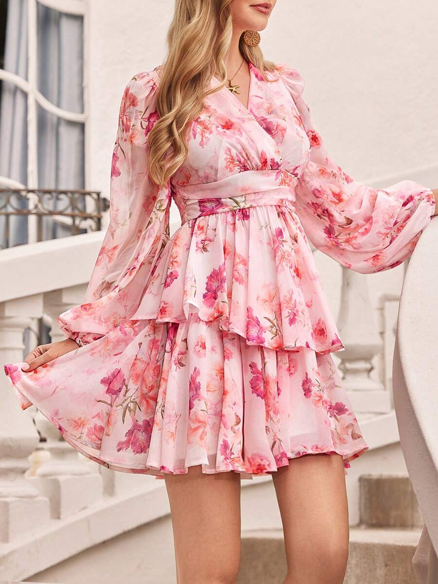 Woman wearing a pink floral dress standing on a staircase.