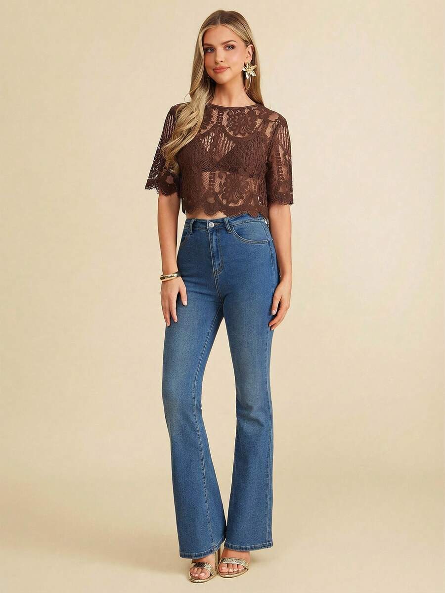 Woman wearing a brown lace top and blue jeans on a beige background