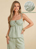 Woman wearing a light green top and pants with a close-up of rhinestone floral pattern on beige background